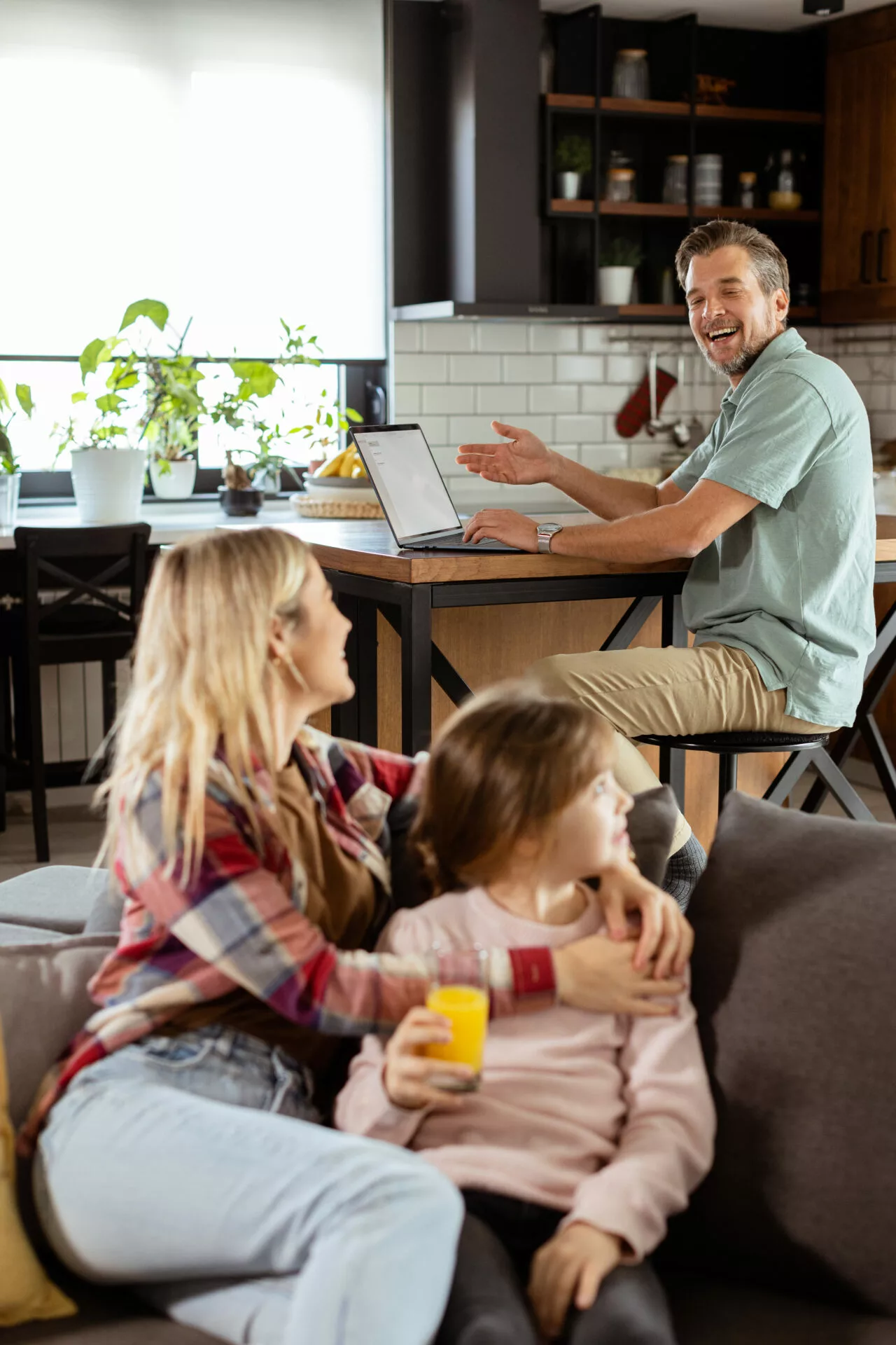 man sharing news from a laptop while being with his family