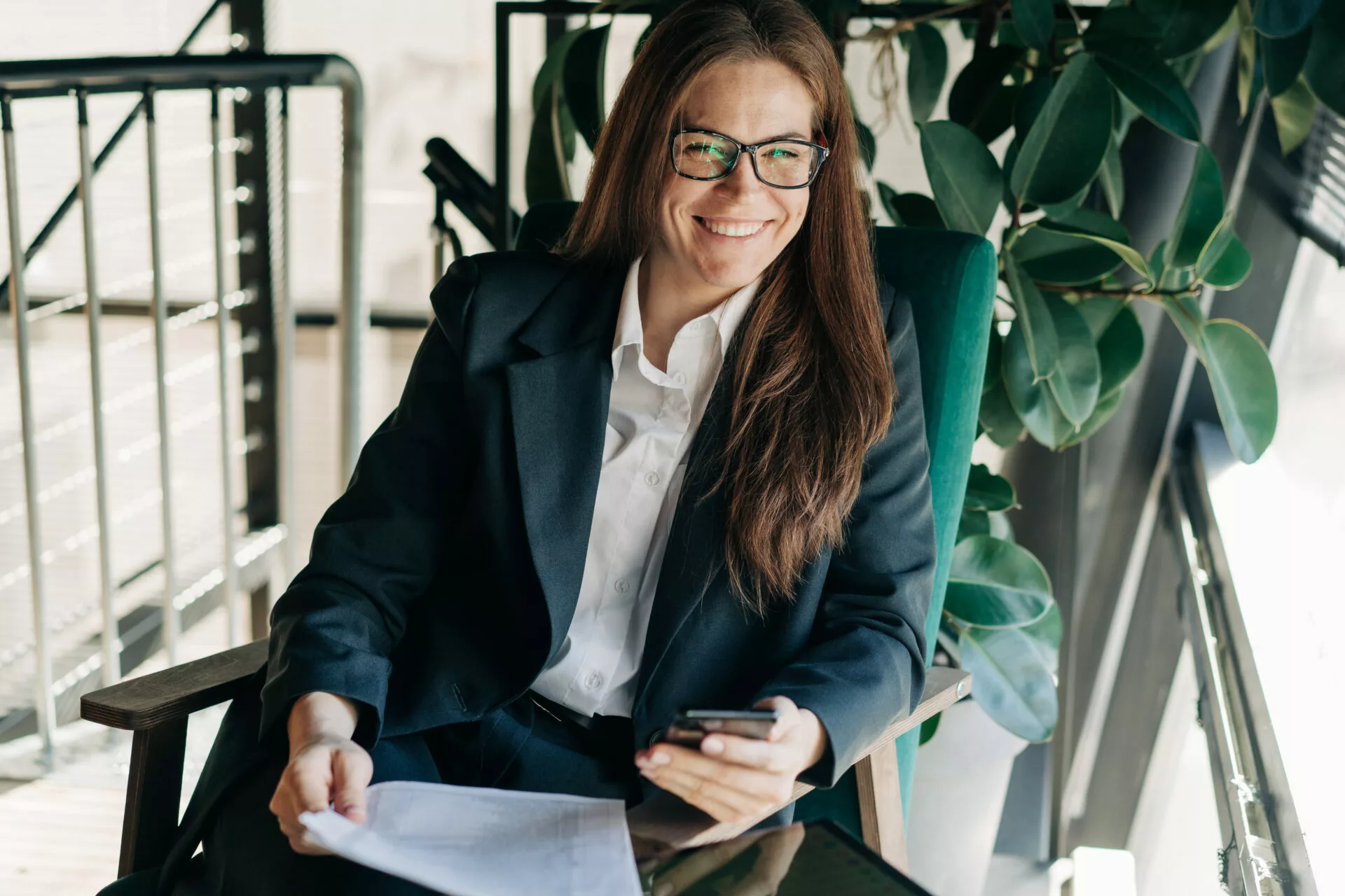 Portrait of a happy laughing business woman sitting at her workplace looking at the camera.